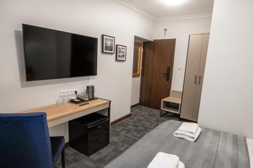 a hotel room with a desk and a tv on the wall at Soul Rooms Old Town Gdansk in Gdańsk