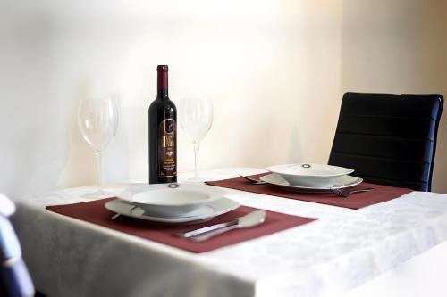 een tafel met twee borden en een fles wijn bij Amélie Apartments in Poreč