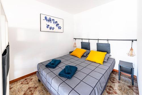 - une chambre avec un lit doté d'oreillers jaunes et bleus dans l'établissement Appartement 2 personnes, proche mer et commodités, à Roquebrune-Cap-Martin