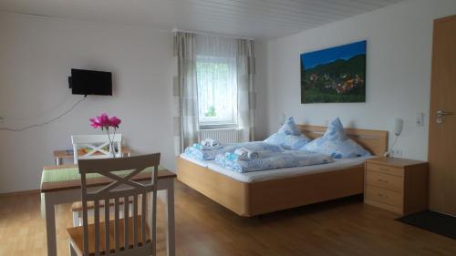 a bedroom with a bed with blue pillows and a desk at Gästehaus Reither in Schweigen-Rechtenbach