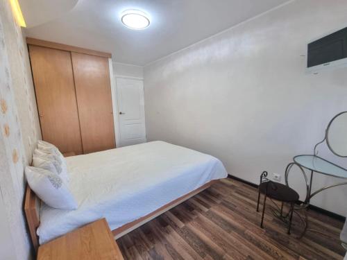 a small bedroom with a bed and a table at Airida Forest Apartment in Druskininkai