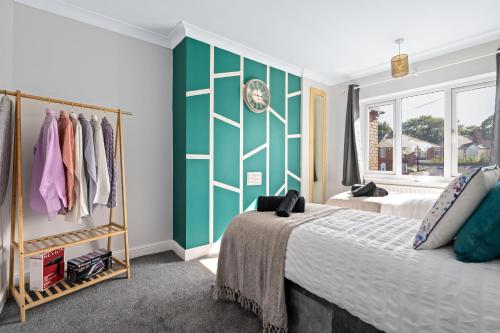 a bedroom with two beds and a green and white wall at Stunning Modern Home 4 mins from Racecourse in Doncaster