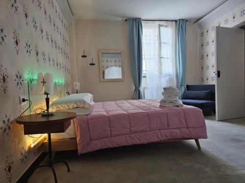 una camera da letto con un letto rosa e un divano blu di Blu Oltremare camere bijoux a Varazze