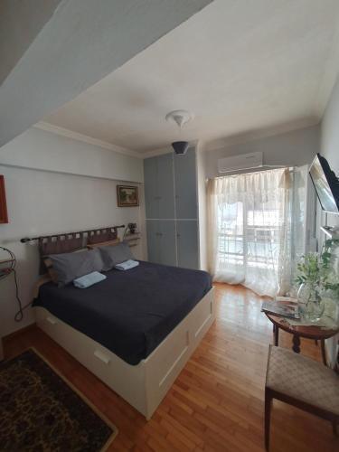 ein Schlafzimmer mit einem großen Bett und einem Tisch in der Unterkunft Smart cozy apartment in Athens! in Athen