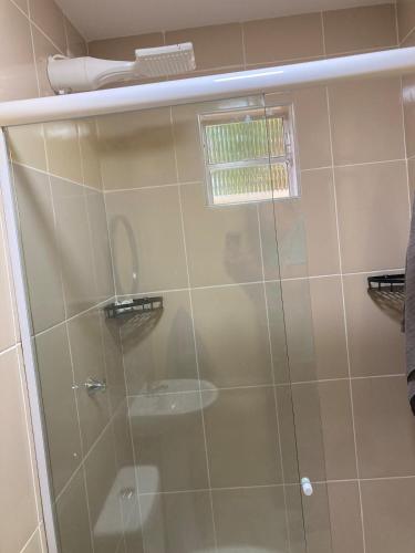 a shower with a glass door in a bathroom at Jeri Cottage in Jericoacoara