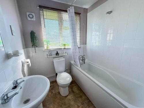 a bathroom with a toilet and a tub and a sink at Superb Chalet, Sleeps 8, Nearby Hemsby Beach In Norfolk Ref 18193B in Hemsby
