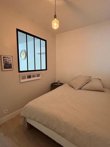 une chambre avec un lit et une fenêtre dans l'établissement Juan-les-Pins 2 pièces avec parking & proches des plages, à Antibes