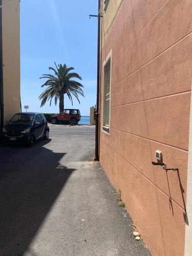 a car parked next to a building with a palm tree at Appartamento piano terra retro in Varigotti