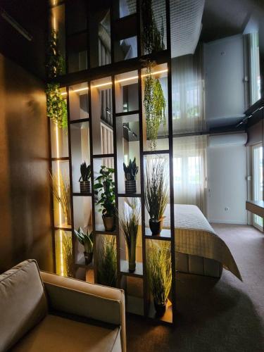 a room with a wall of potted plants at Harmony Apartments in Podgorica