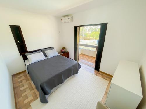 a bedroom with a bed and a view of a balcony at Nossa Casa em Vilas - 70 m da areia - 6 Suítes in Lauro de Freitas