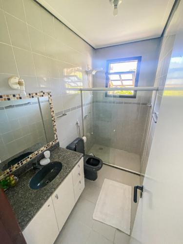 a bathroom with a sink and a toilet in it at Nossa Casa em Vilas - 70 m da areia - 6 Suítes in Lauro de Freitas