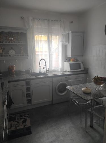 une cuisine avec un évier et une machine à laver dans l'établissement Appartement T3 centre ville, à Ajaccio