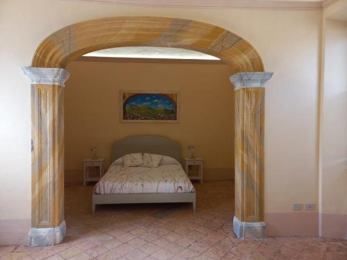 a bedroom with an archway with a bed in it at La casetta sull'arco in Sarteano