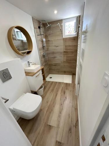 une salle de bain avec toilettes, lavabo et miroir dans l'établissement Appart T2 calme aux terrasses, à Cassis