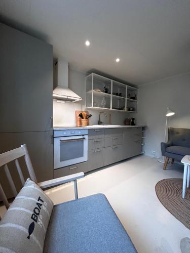 a kitchen with gray cabinets and a couch in a room at Casa Lofoten Ramberg Beach Sauna Surfing Kvalvika Reine in Ramberg
