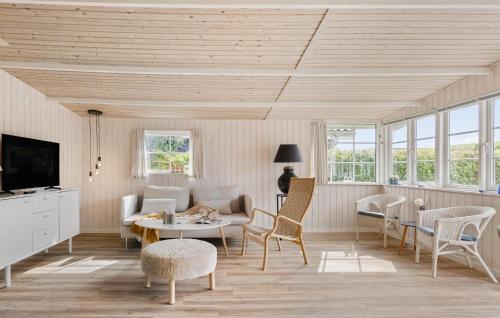 Una sala de estar con un sofá, una mesa y sillas. en Lovely Home In Bjert With Kitchen, en Binderup Strand