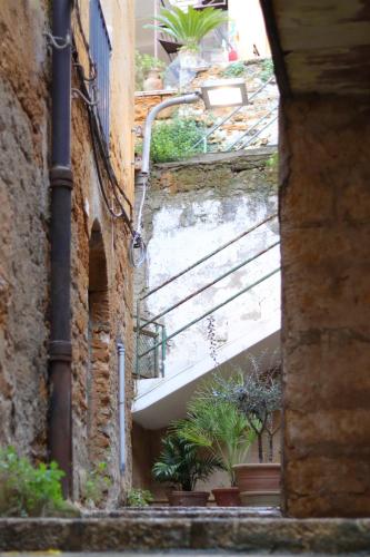 an alley with stairs and potted plants on a building at Casa Damarete in Agrigento