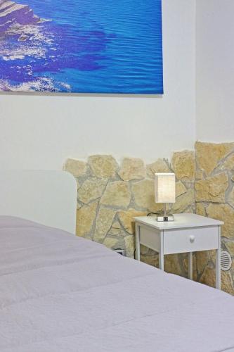 a bedroom with a bed and a table with a lamp at Casa Damarete in Agrigento