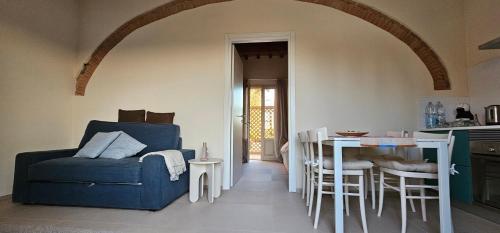 Una sala de estar con un sofá azul y una mesa. en Il Tinaio, en Soianella
