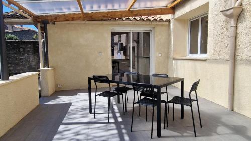 une table noire et des chaises sur une terrasse dans l'établissement Détente, à Magalas