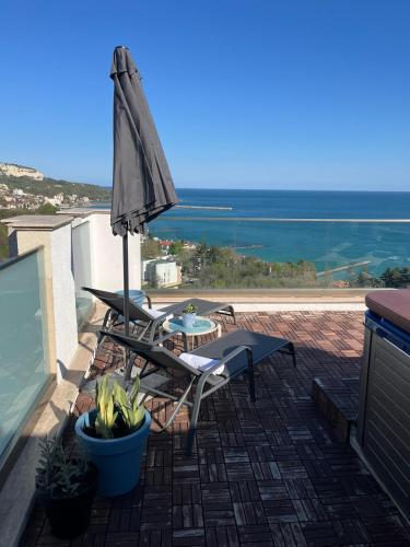 a patio with an umbrella and chairs and a table at Queen's Penthouse Balchik apartment in Balchik