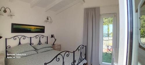 a white bedroom with a bed and a window at Cottage sul golfo in Lerici