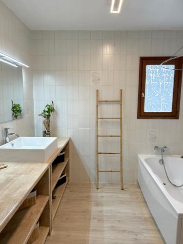 une salle de bain avec un lavabo et une baignoire dans l'établissement Villa de charme Porto-Vecchio, Plage à 10 min, à San-Gavino-di-Carbini