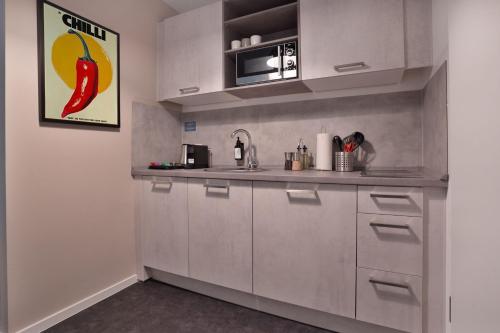 a kitchen with stainless steel cabinets and a microwave at Stilvolle Apartments in der Osnabrücker Innenstadt I home2share in Osnabrück