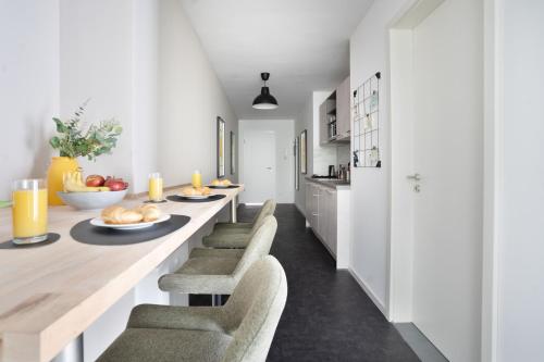 a kitchen with a long dining table and chairs at Stilvolle Apartments in der Osnabrücker Innenstadt I home2share in Osnabrück