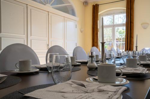 a dining room with a long table with glasses at Hotel Villa Tripaldi in Schönberg in Holstein