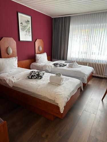 two beds in a room with red walls at Bone To in Salzgitter