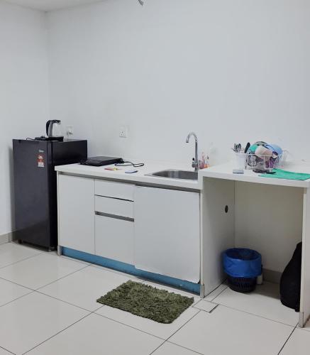 a kitchen with a sink and a refrigerator at Trefoil in Setia Alam