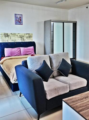 a living room with a couch and a bed at Trefoil in Setia Alam