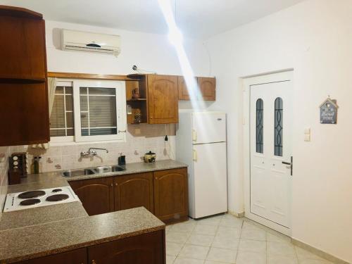 a kitchen with a white refrigerator and a sink at Παραθαλάσσια Κατοικία Στον Άγιο Μερκούριο Ευβοίας in Mourteri