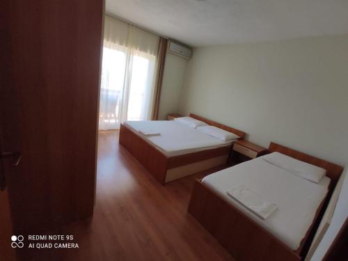 a small room with two beds and a window at Apartmani Erlic in Turanj