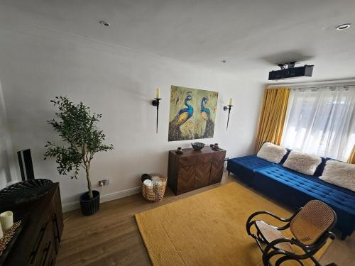 a living room with a blue couch in a room at Braveheart Haven: 4BD Retreat with Hot Tub in Stirling