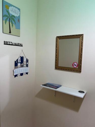 a mirror on a wall next to a shelf at Casa Brezza Marina in Scalea