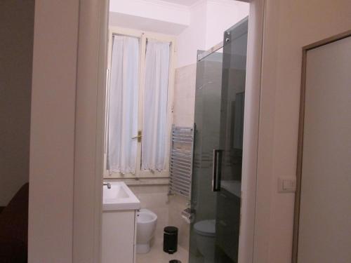 Un baño con lavabo, inodoro y ventana. en Trevi Elegance Suite, en Roma