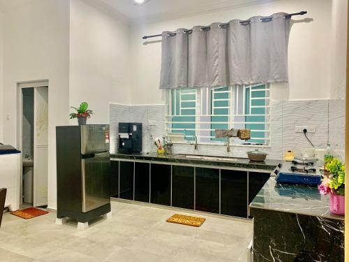 a kitchen with a window and a counter top at Rantau Panjang Nazirah Homestay in Rantau Panjang
