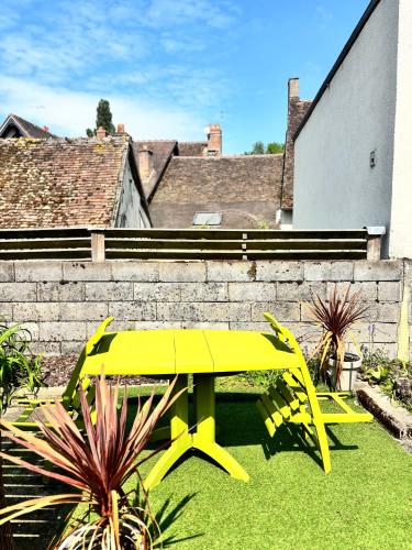 a yellow table and chairs in a yard at Au Champ Fleuri in Bracieux