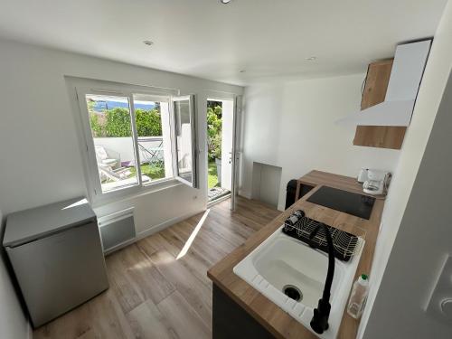 une petite cuisine avec un évier et une fenêtre dans l'établissement Studio Calme aux terrasses de Cassis, à Cassis