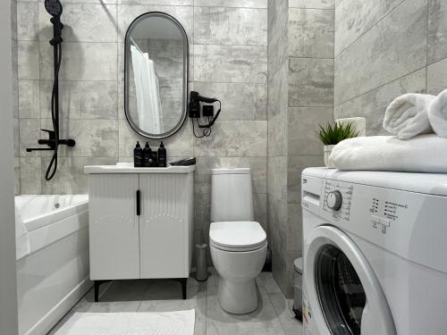 a bathroom with a washing machine and a mirror at Арман комфорт in Aktobe