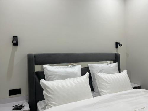 a bed with white pillows in a bedroom at Арман комфорт in Aktobe