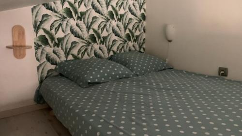 a bed with two pillows in a bedroom at Studio cosy avec jardin in Jonquières