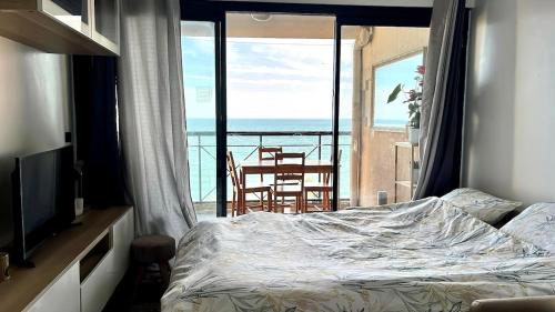 une chambre avec un lit et une vue sur l'océan dans l'établissement Cannes cozy 4-person appartement piscine, vue mer exceptionnelle, à Cannes