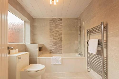 een badkamer met toilet, bad en wastafel bij Stanley-3 Bdrm House Ideal for Contractors Near Beach in Blythe