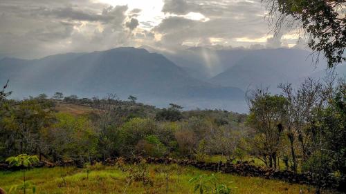 a view of a mountain from a field with trees at El Paraiso - B&B Finca San Vicente in Barichara