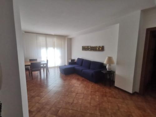 a living room with a blue couch and a table at Affittacamere Vetuliae Foligno in Foligno