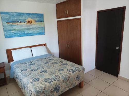 a small bedroom with a bed and a door at Habitación en Condominio frente al mar Nuevo Vallarta in Nuevo Vallarta