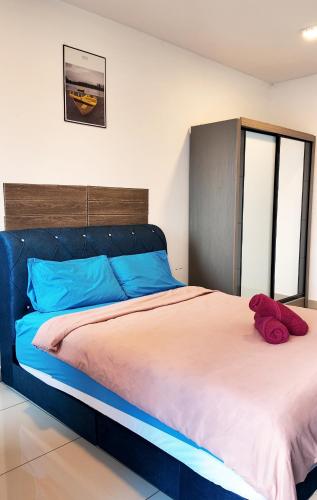 a bedroom with a large bed with a red stuffed animal on it at Trefoil in Setia Alam